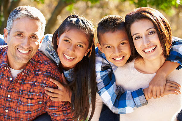 Portrait Of Hispanic Family In Countryside Smiling To Camera