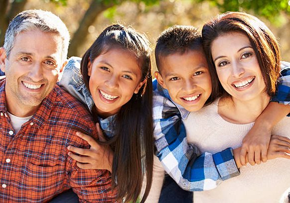 Portrait Of Hispanic Family In Countryside Smiling To Camera